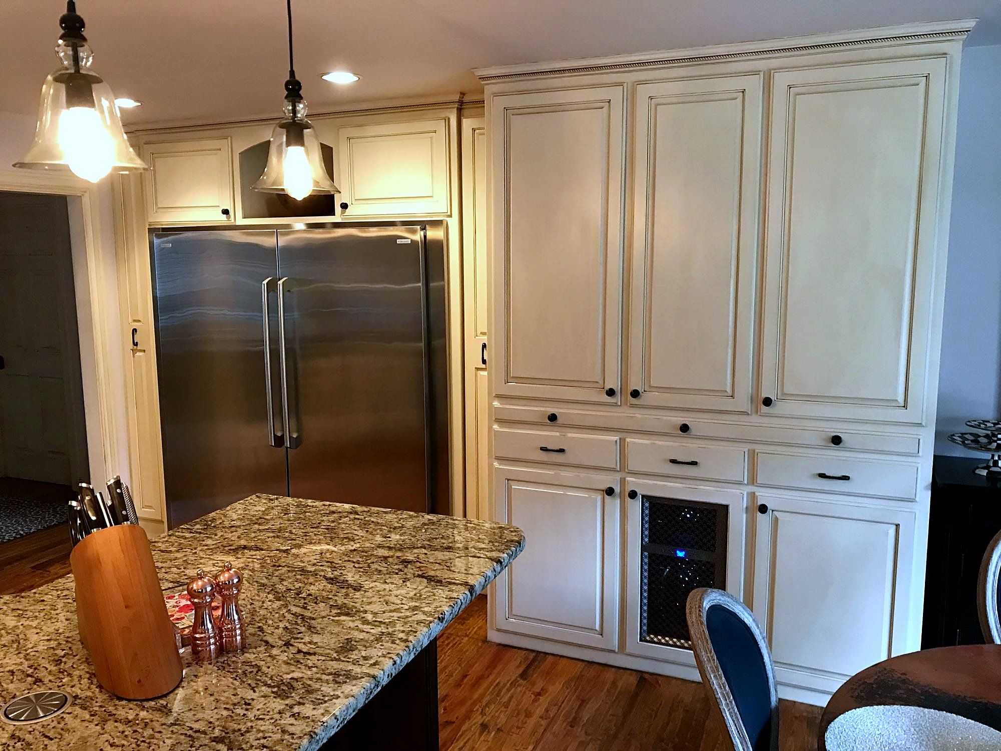 Cream kitchen cabinets with granite countertops and a stainless steel built-in refrigerator