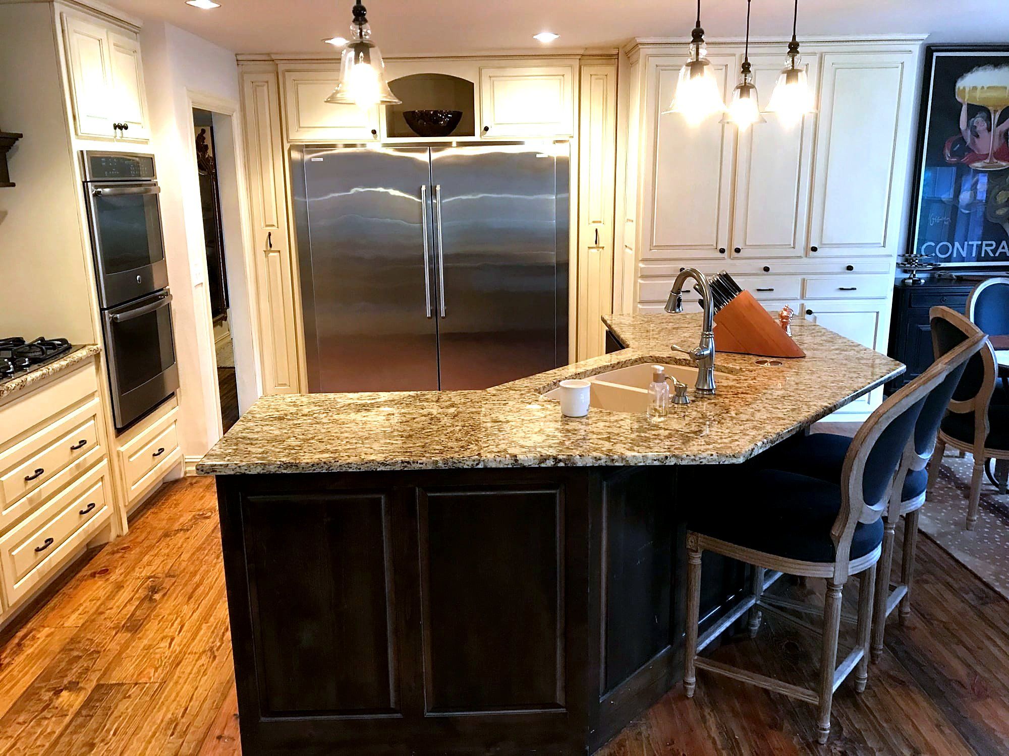 Kitchen island with dark wood cabinetry, a granite countertop, and pendant lighting over bar seating